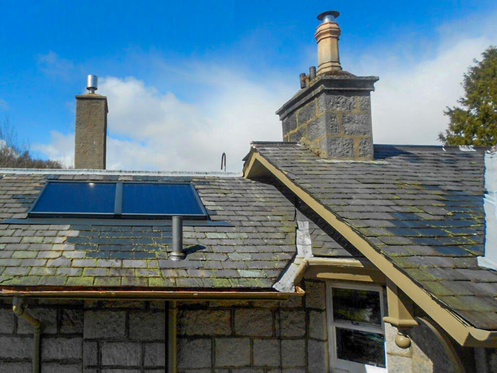 A close up of a building within Her Majesty's Balmoral Estate with 2 x solar thermal panels (the AES Luminary panel) installed on the roof.