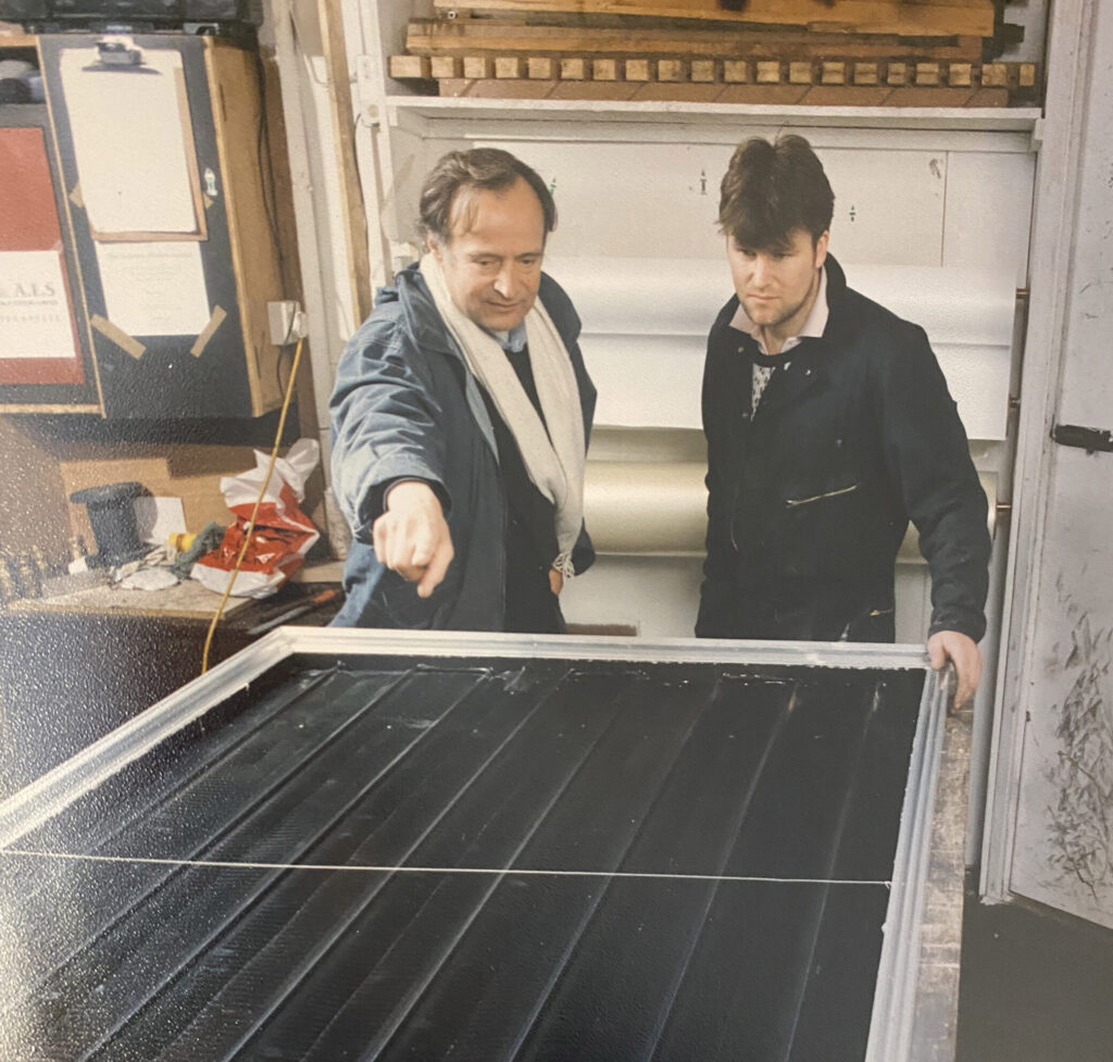George Goudsmit points at a solar panel to a colleague