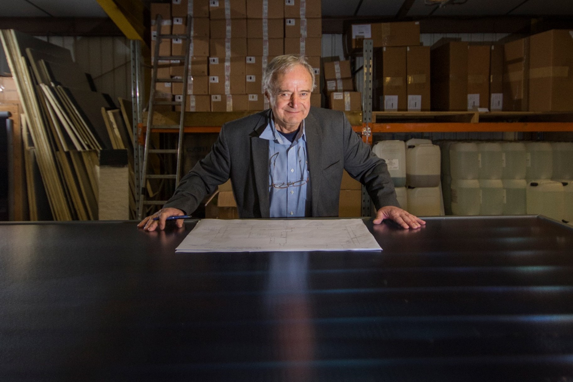 George Goudsmit, uses a solar panel as a desk and examines a technical drawing after AES Solar win Queen's Award.