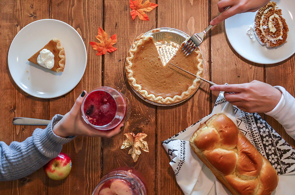 People cutting into a pumpkin pie for a Sustainable Halloween 2022.
