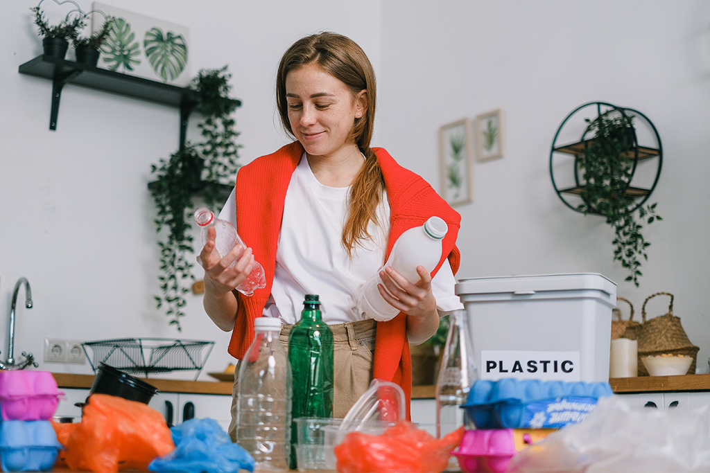 Eco-Friendly New Year’s Resolutions woman surrounded by plastic recycling