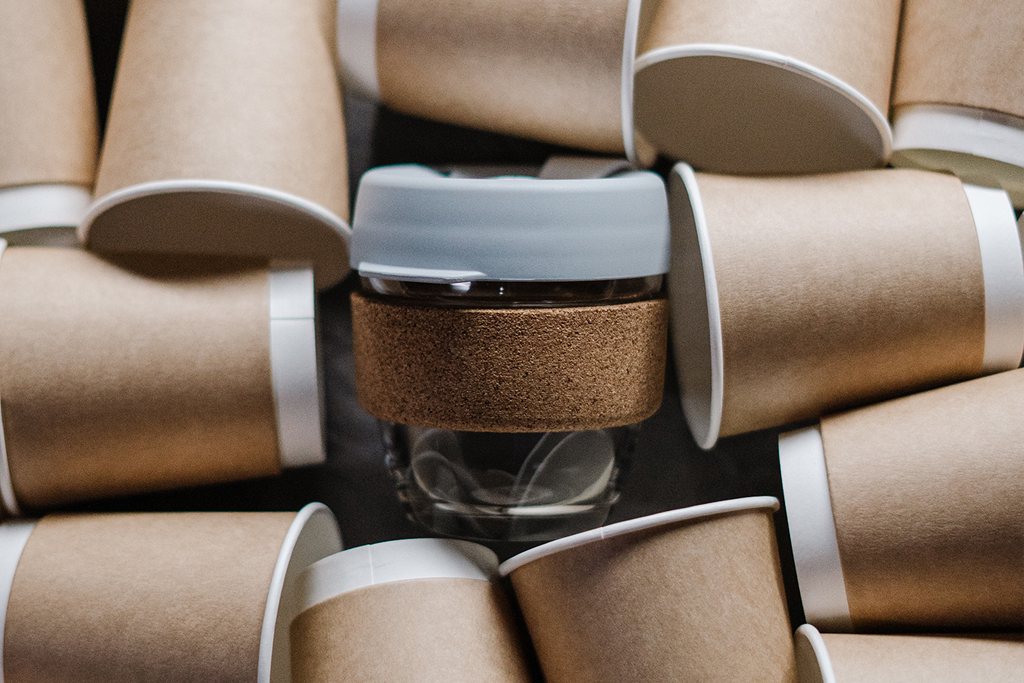 Eco-Friendly New Year’s Resolutions reusable coffee cup surrounded by other single-use coffee cups