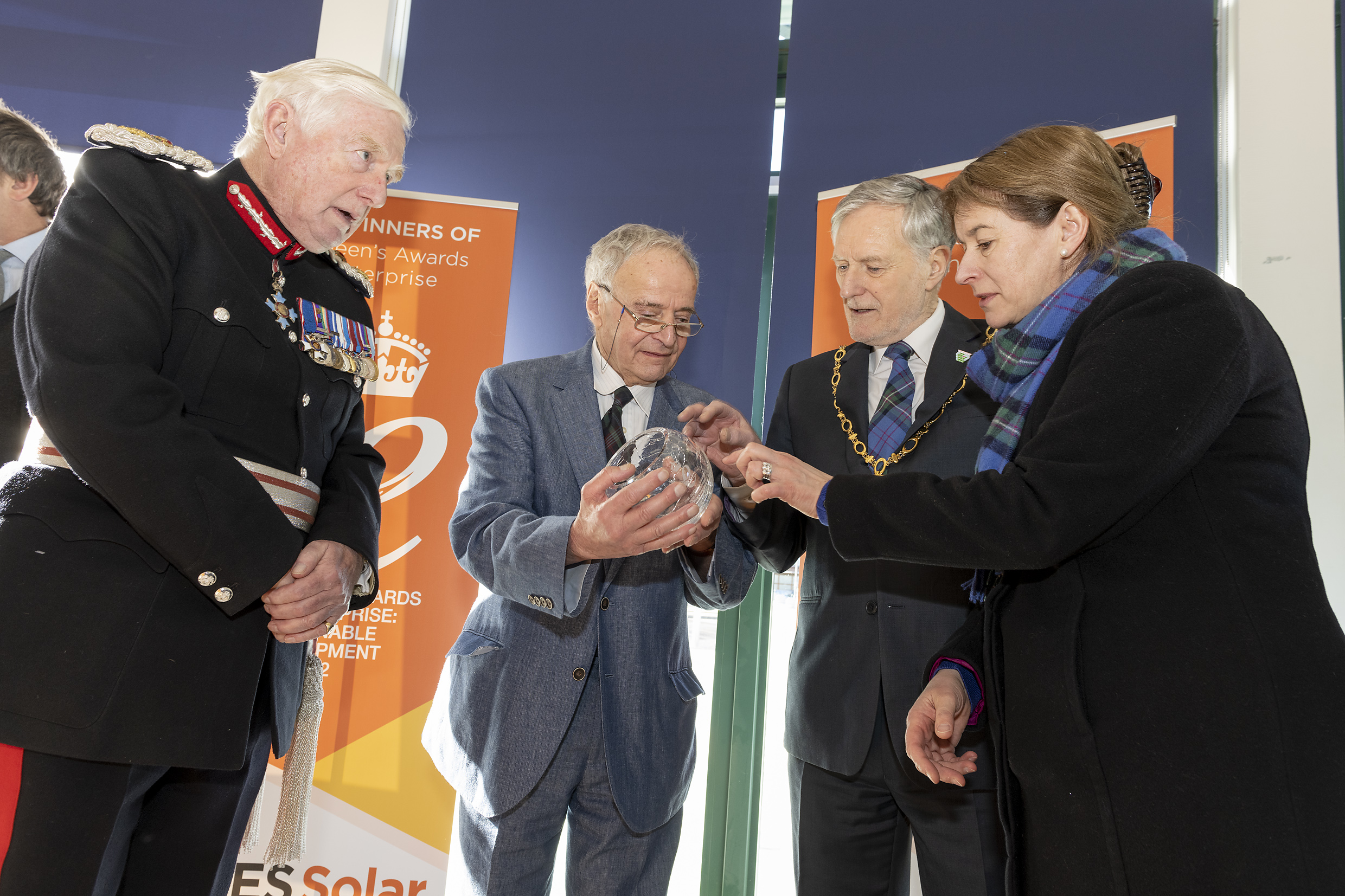 Attendees gather to admire the trophy at Our Queen's Award Presentation! 