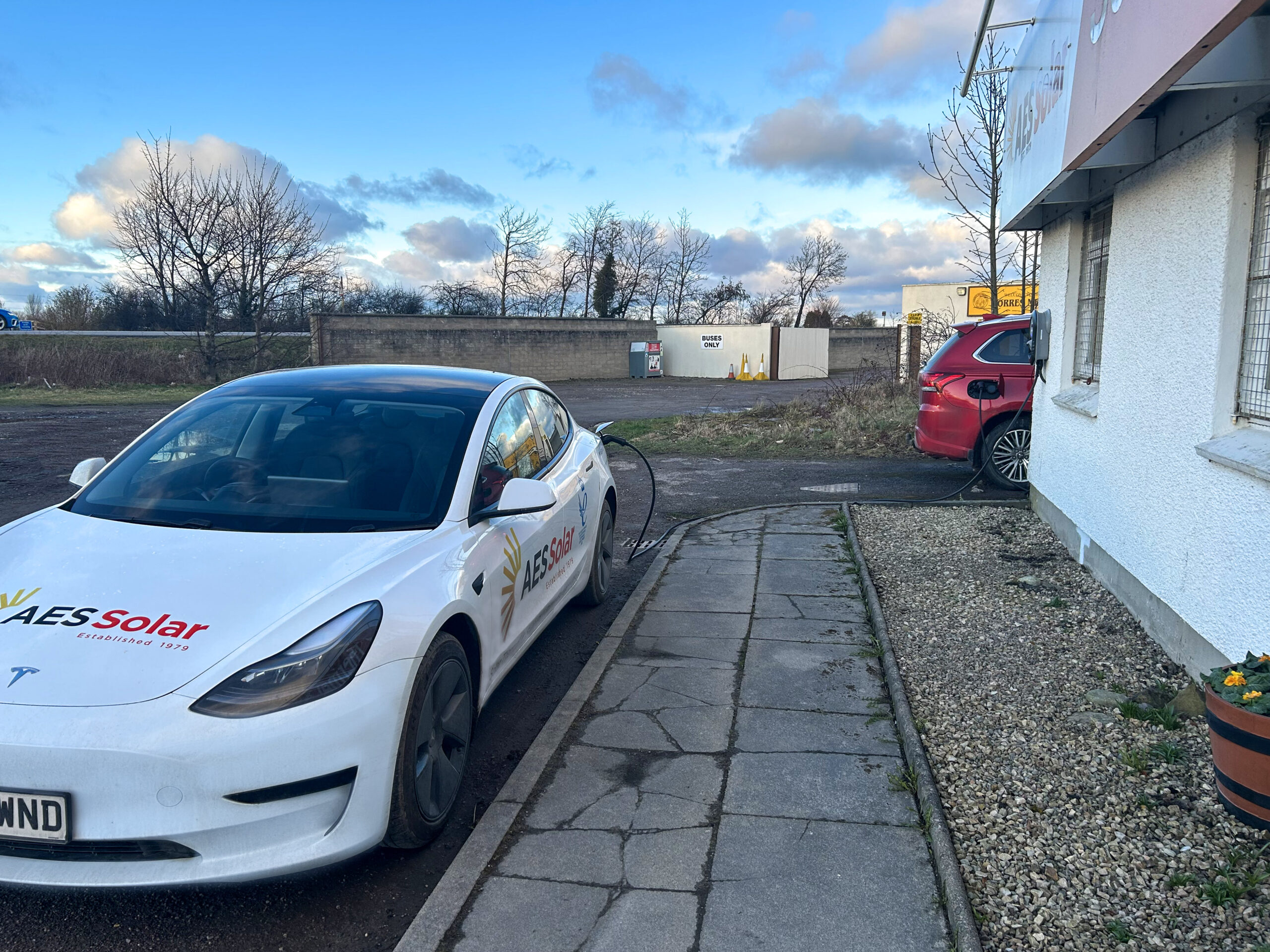 AES Solar on the road with a Tesla Model 3 charging at the head office in Forres