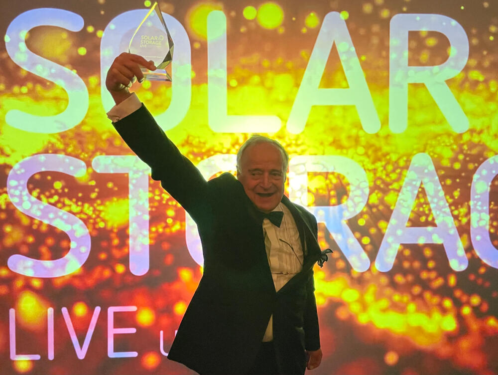 AES Solar founder steps down shown celebrating with an arm in the air holding a trophy